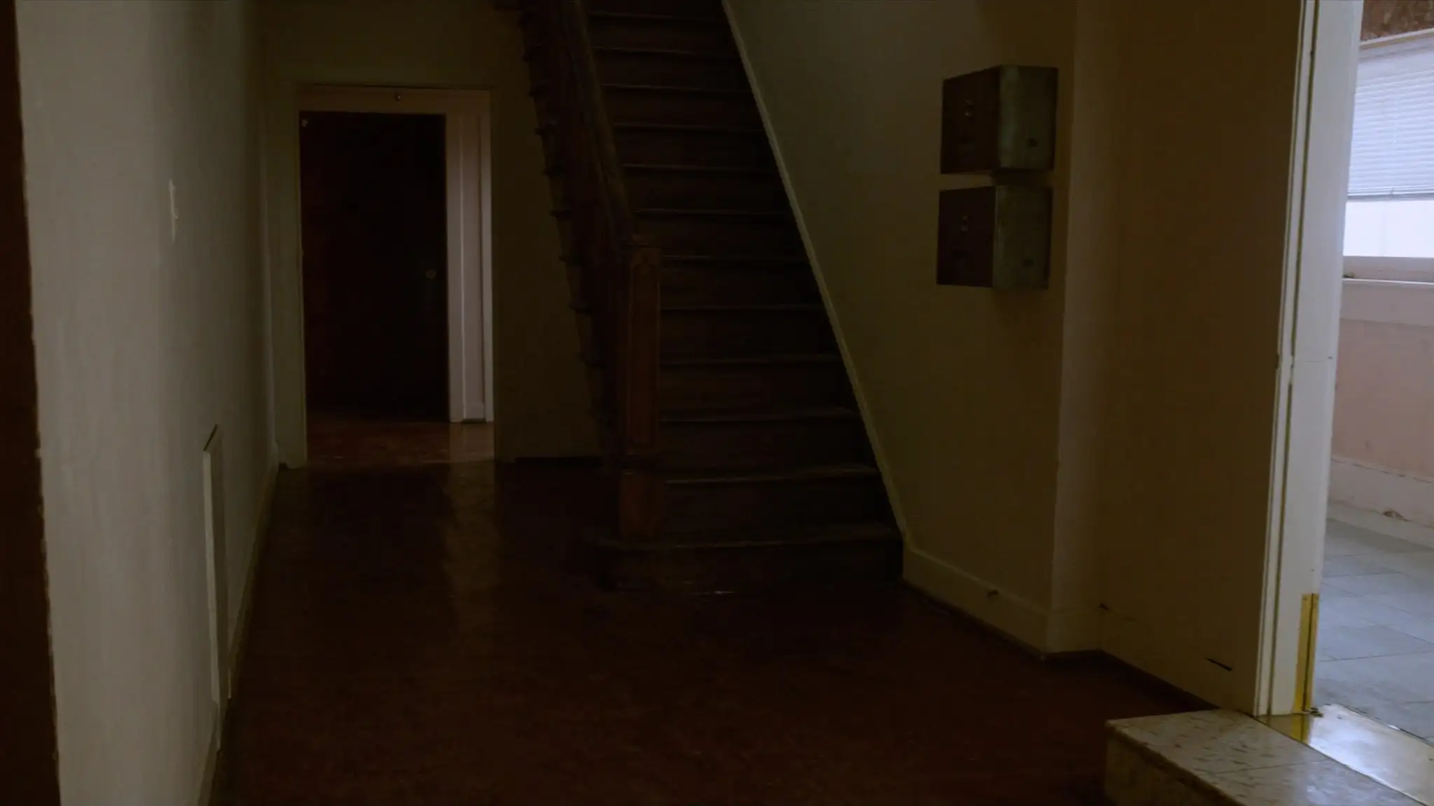 Entry hallway of an older two-flat with mailboxes and a staircase