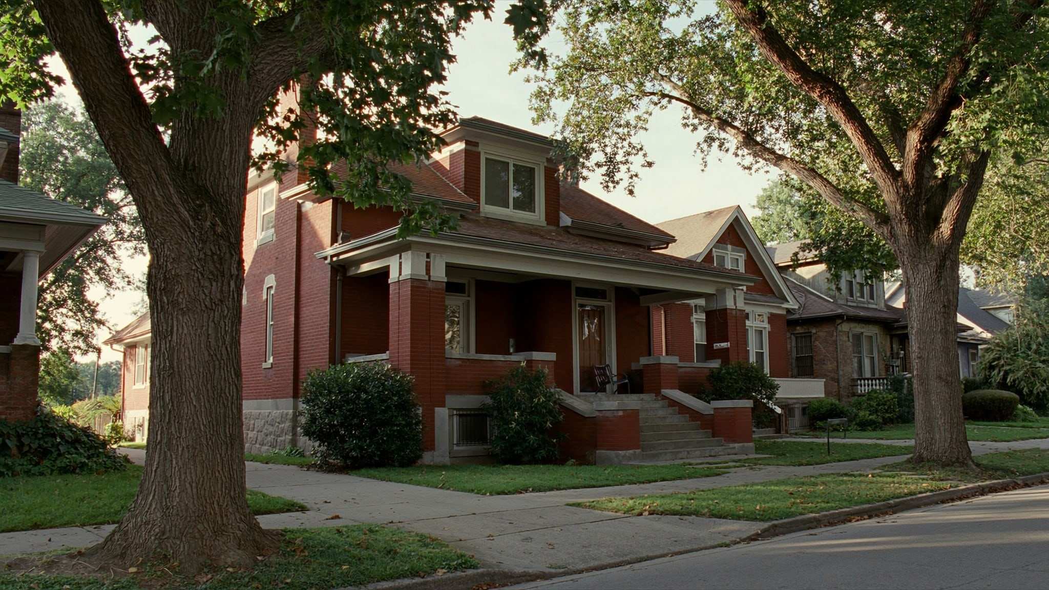 Brick bungalow with a deep front porch on a tree-lined street in an older Lake County neighborhood