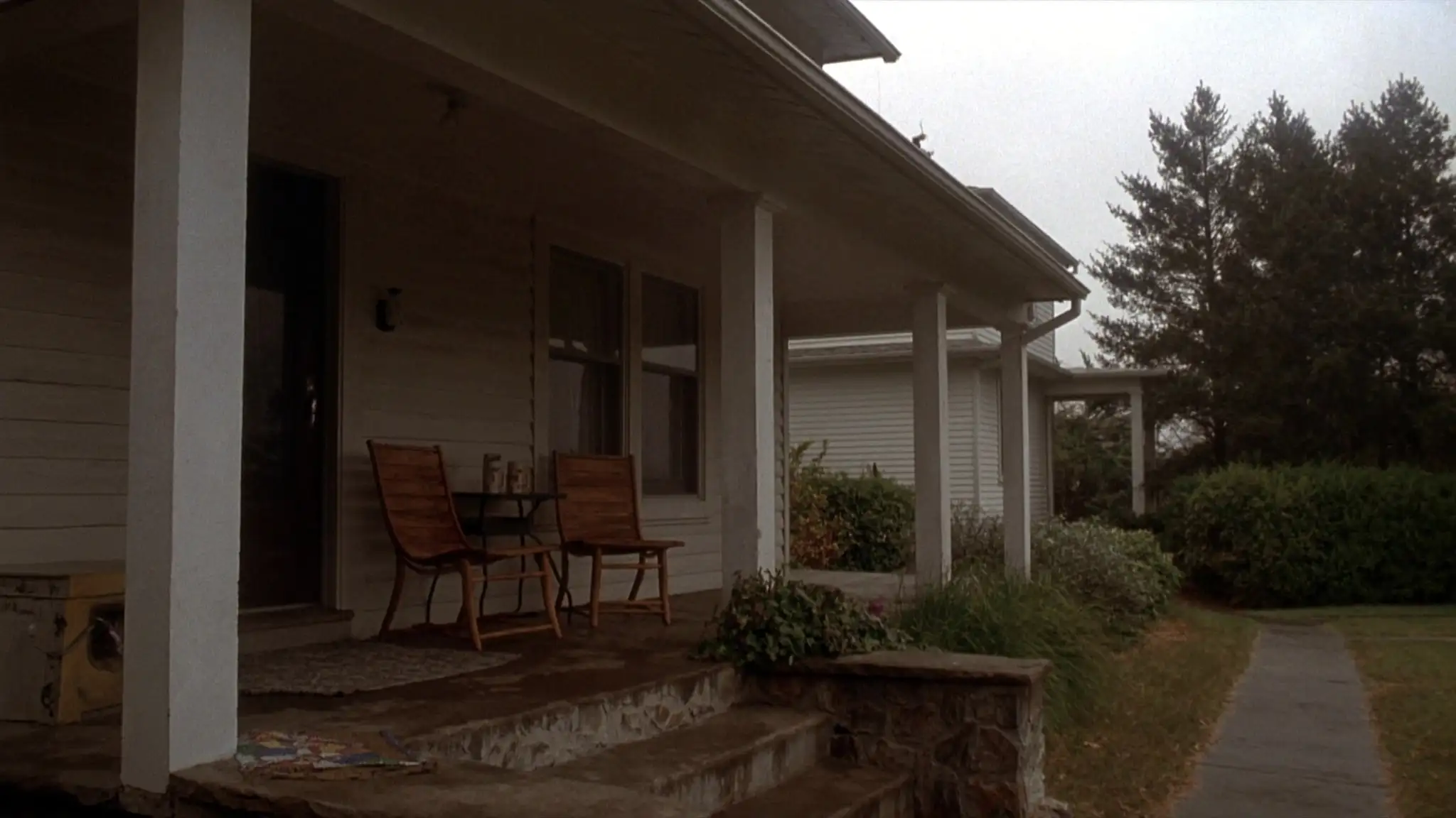 Front porch of a two-story house with two chairs