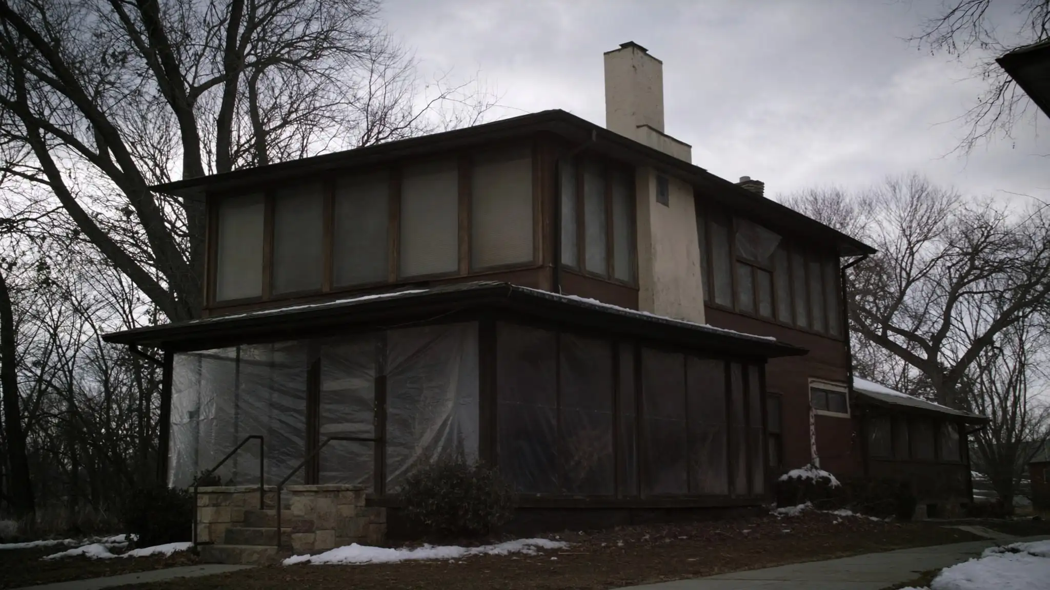 Vacant two-story house in winter with snow in the yard